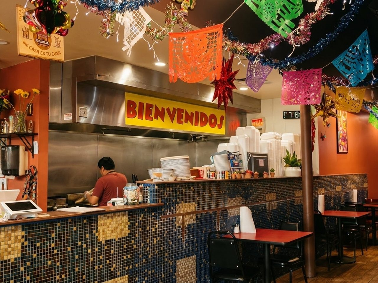 Orange walls, papel picado, and a BIENVENIDOS sign