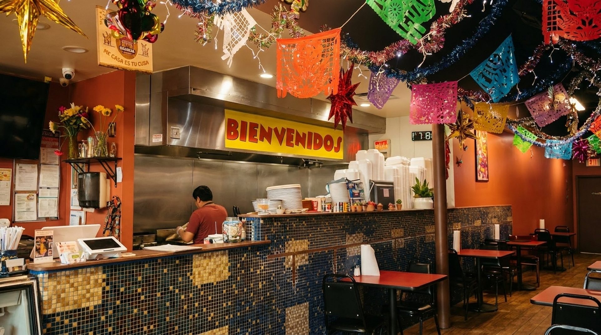 Orange walls, papel picado, and a BIENVENIDOS sign